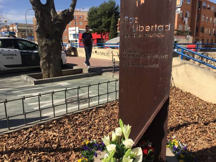 Imagen del ramo de flores depositado junto al monolito en homenaje a las víctimas del 11-M.